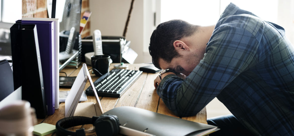 Tired man napping on the working desk