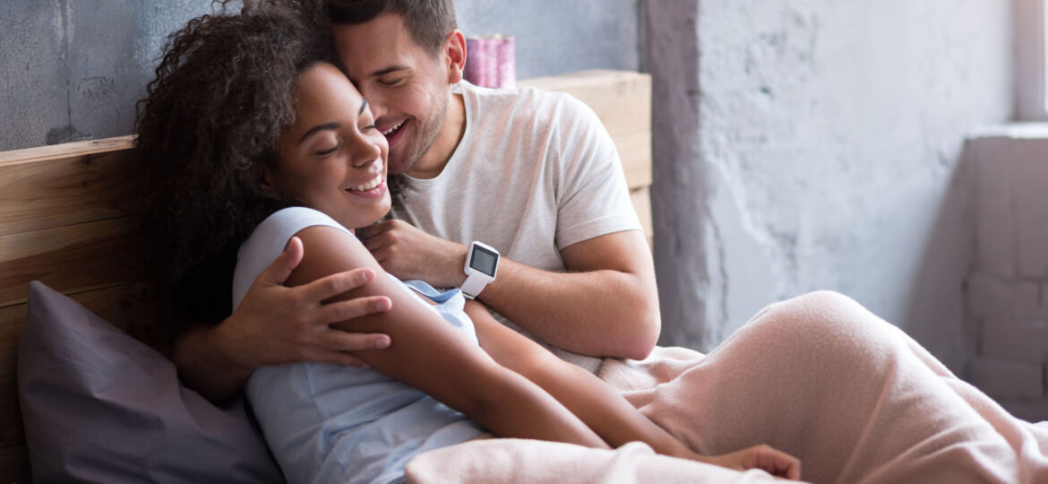 Young couple embracing in their bed tenderly